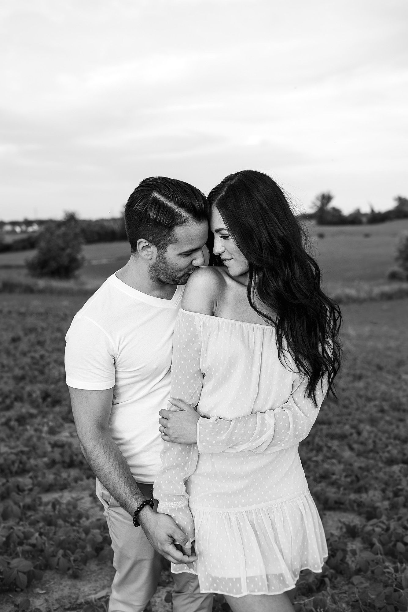 Romantic black and white portraits captured in a field at sunset.