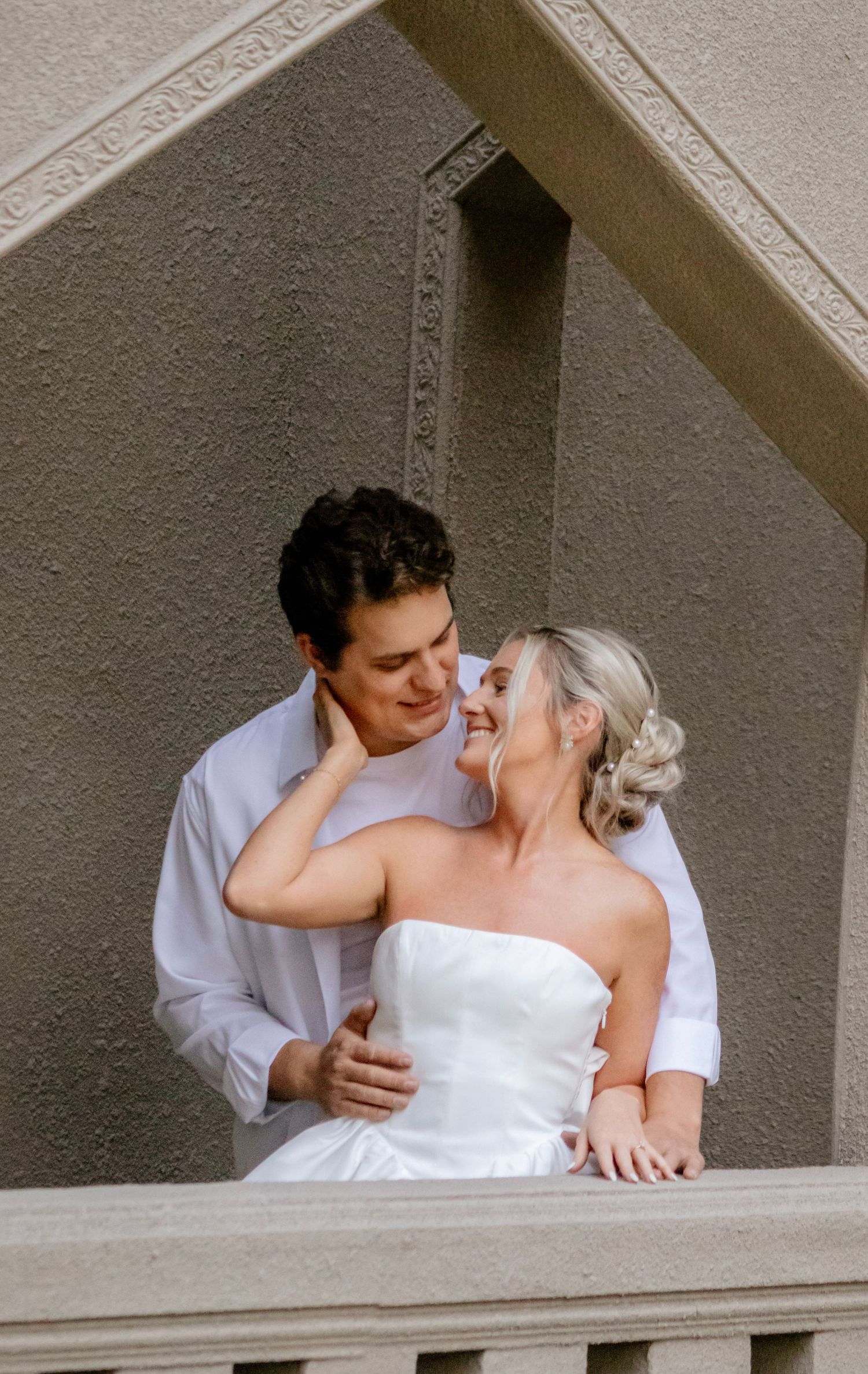A tender moment captured between newlyweds in an architectural alcove.