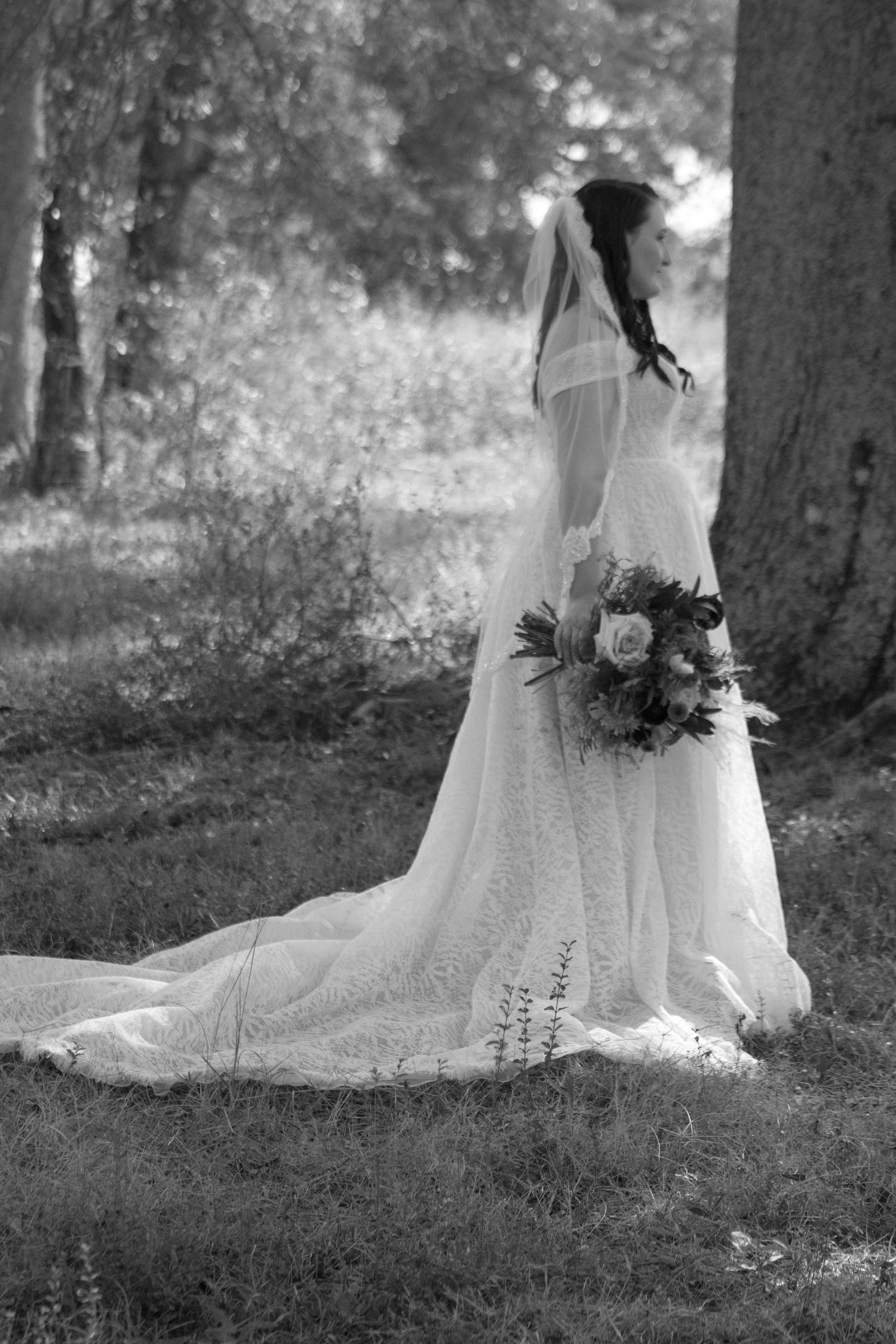 Black and white photos of a flowing wedding dress train spread across grass in a garden setting.