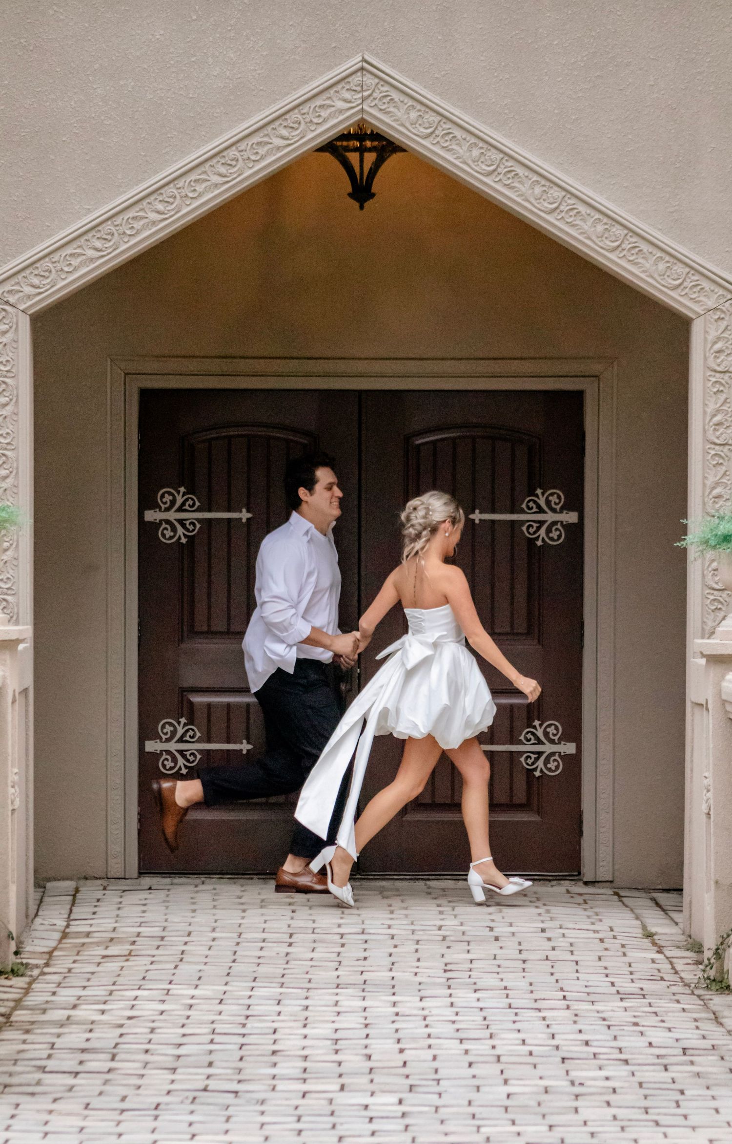 Playful wedding photo sequence under arched doorways with stone details.
