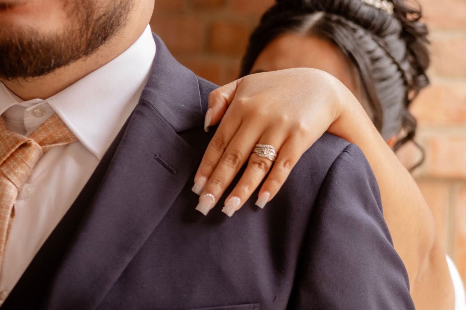 Close-up shot of hands exchanging wedding rings during an elegant ceremony.