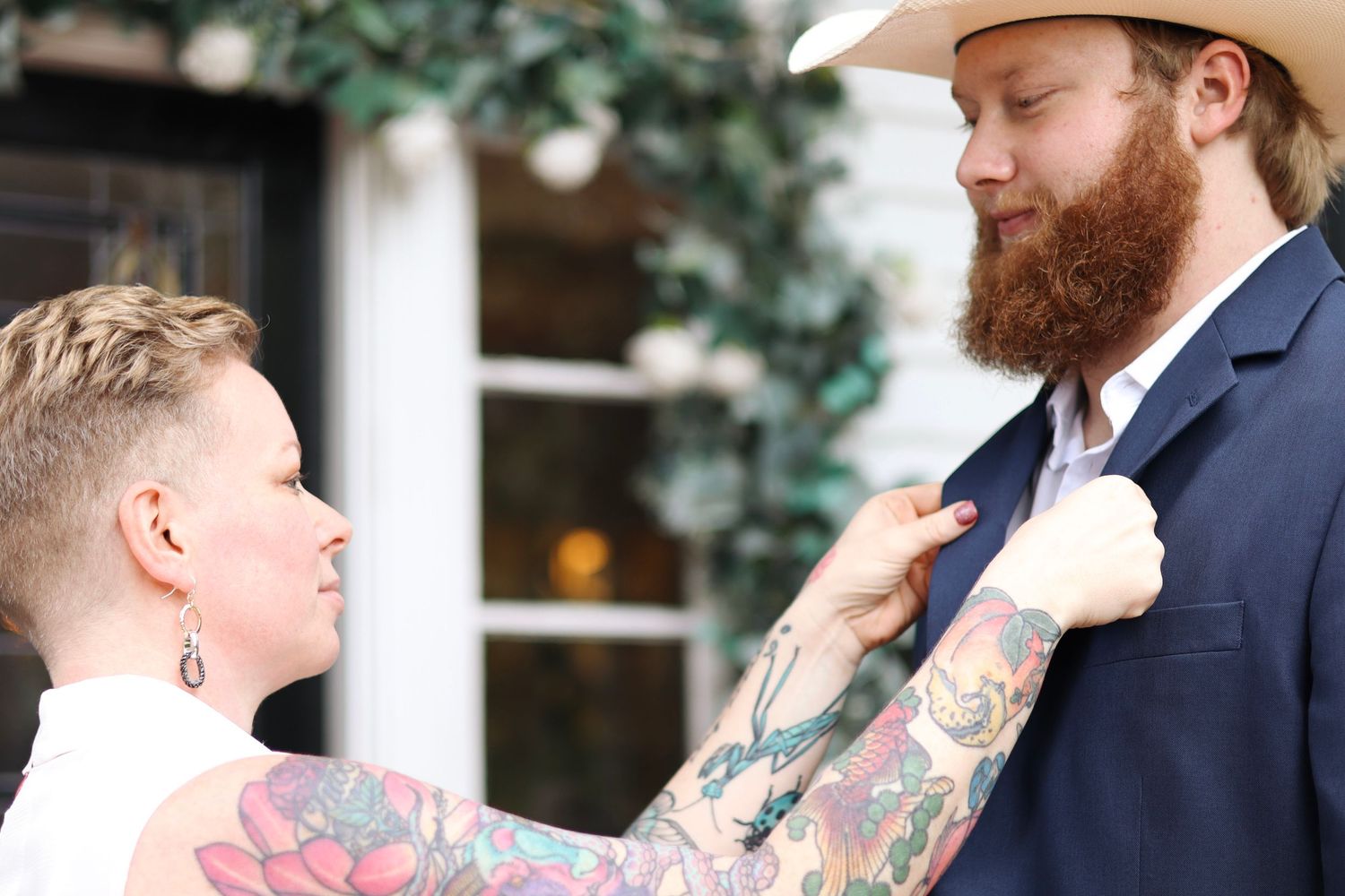 Wedding party members in navy suits and cowboy hats share candid moments outdoors.