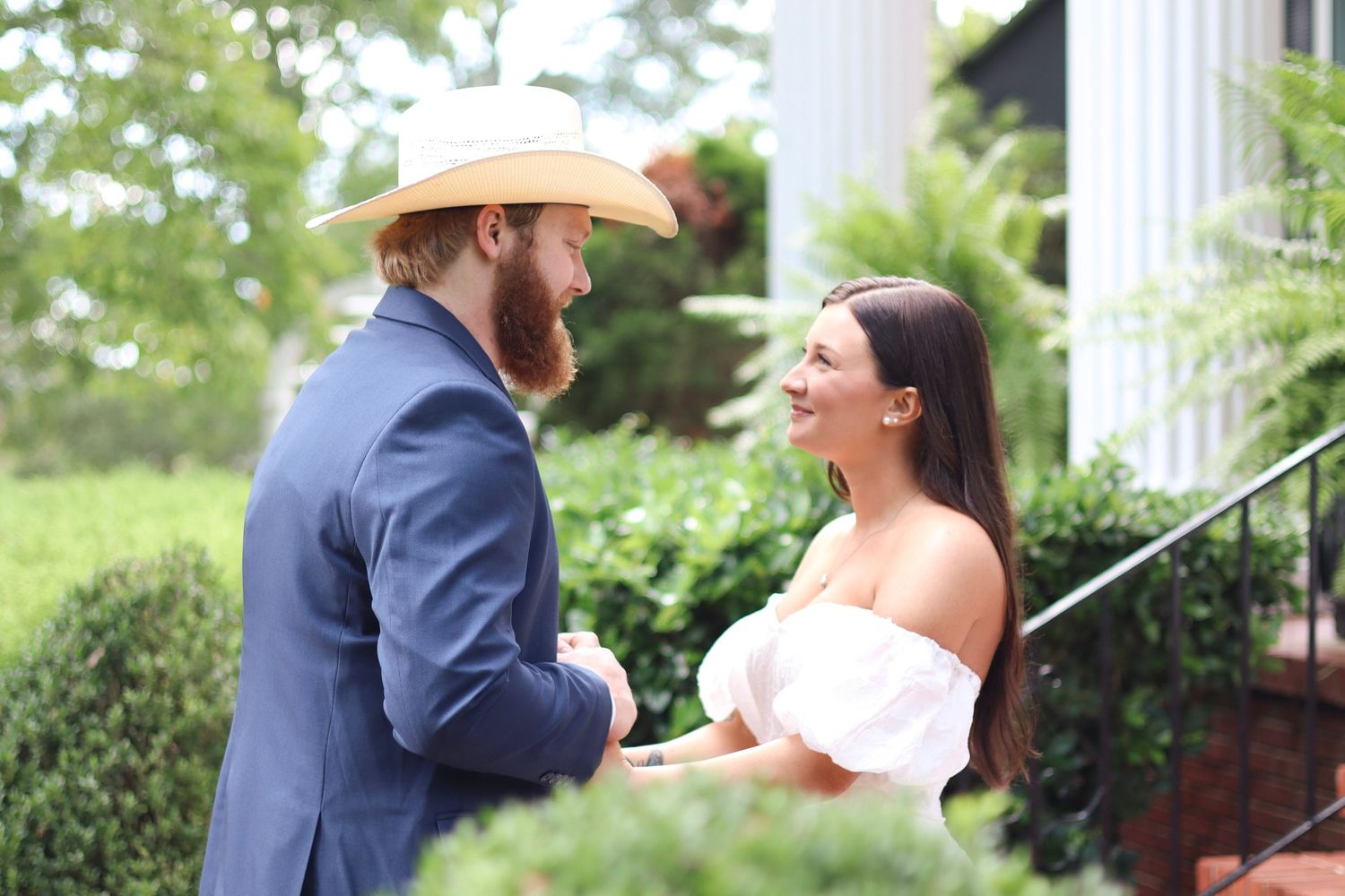 Candid wedding moments captured outdoors with greenery and white columns in the background.