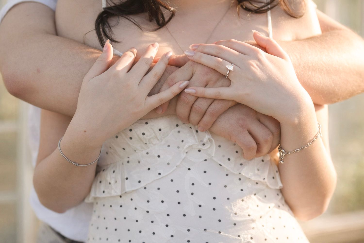 Close-up shots of hands holding a white polka dot dress fabric, showing details of the delicate pattern and texture.