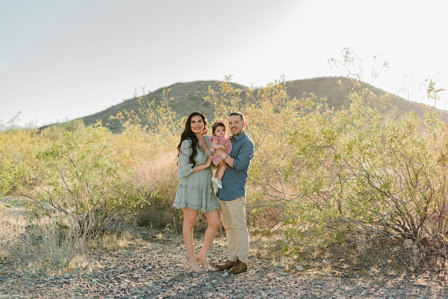 family with young daughter poses on a rocky desert trail during a phoenix mini session at south mountain park