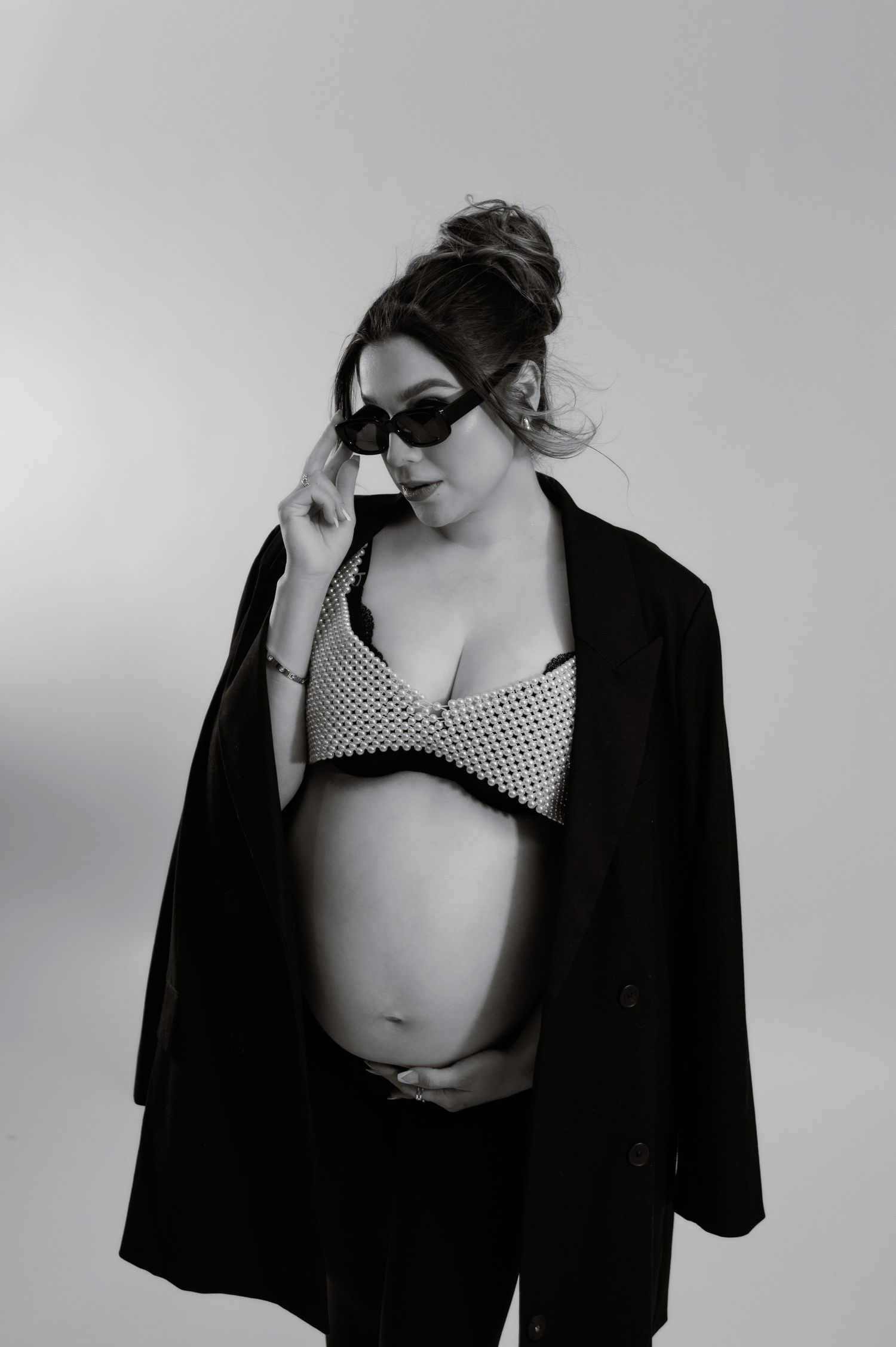 pregnant woman in sunglasses and a black blazer poses during a phoenix editorial maternity session