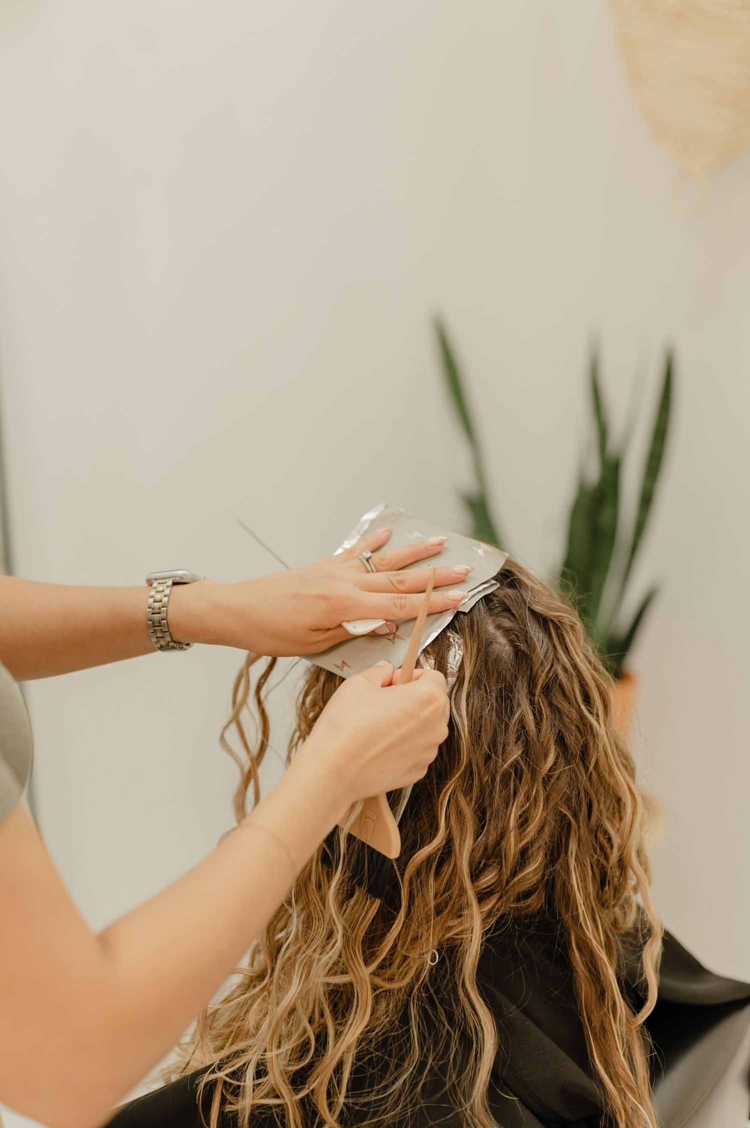 Precision curl cut in progress—Serena Beach shaping defined, hydrated curls inside Salon Blissful’s bright studio.