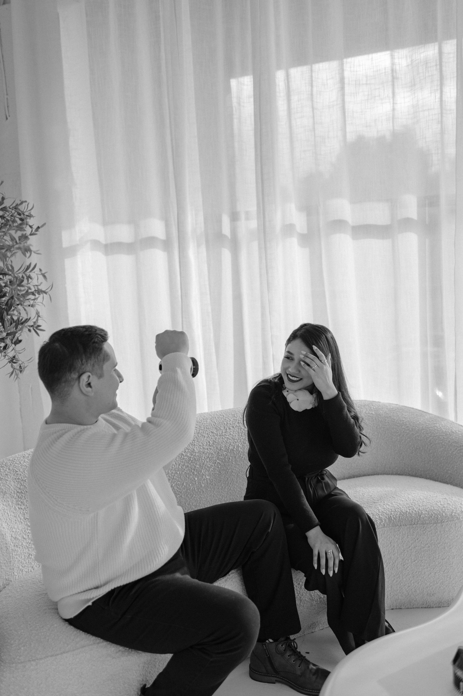 Black-and-white image of the team sitting casually in a bright room — modern lifestyle aesthetic.