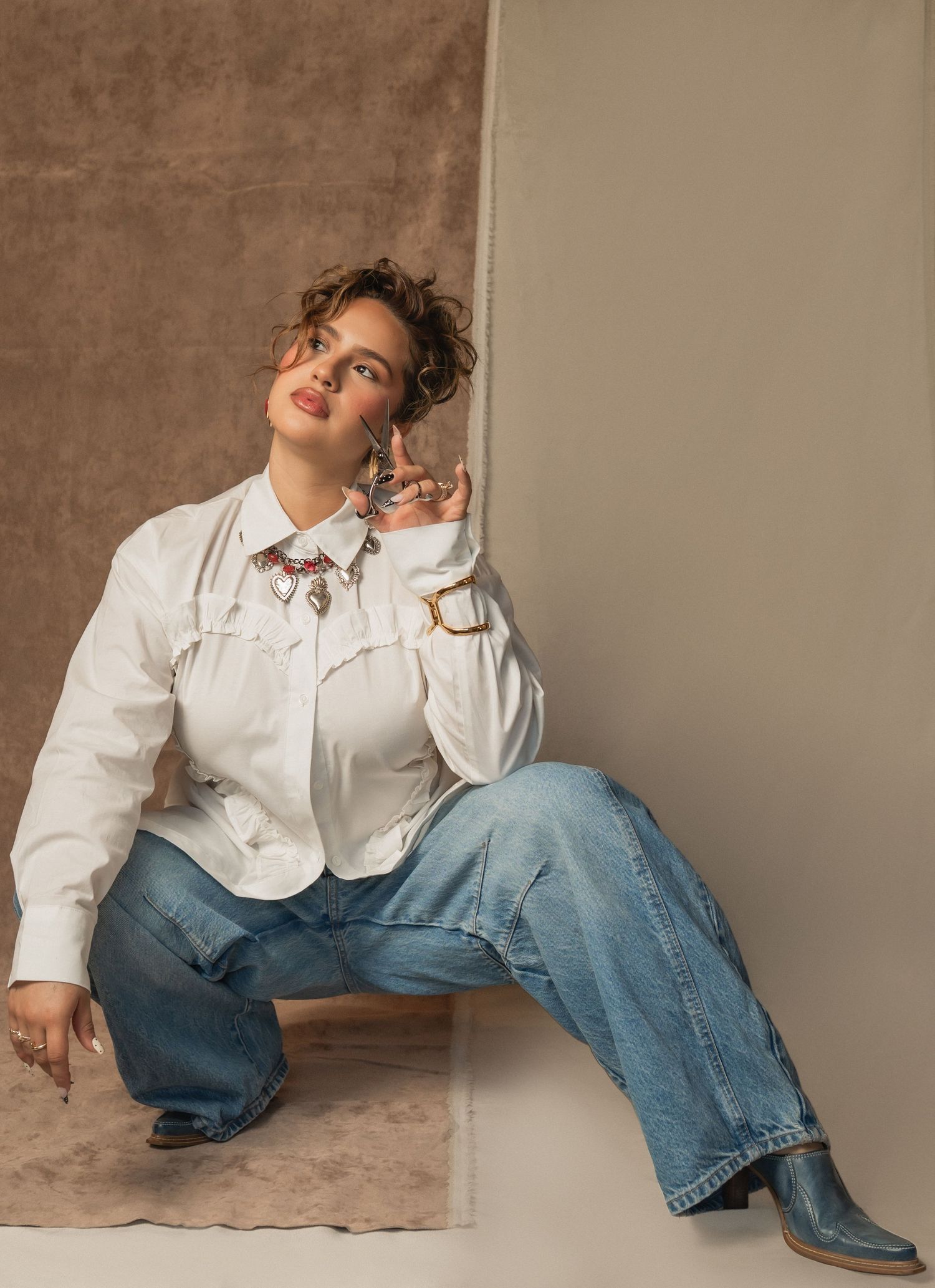 Casual portrait of a smiling woman in jeans and a white button-up — behind the scenes at The Hive Salon.