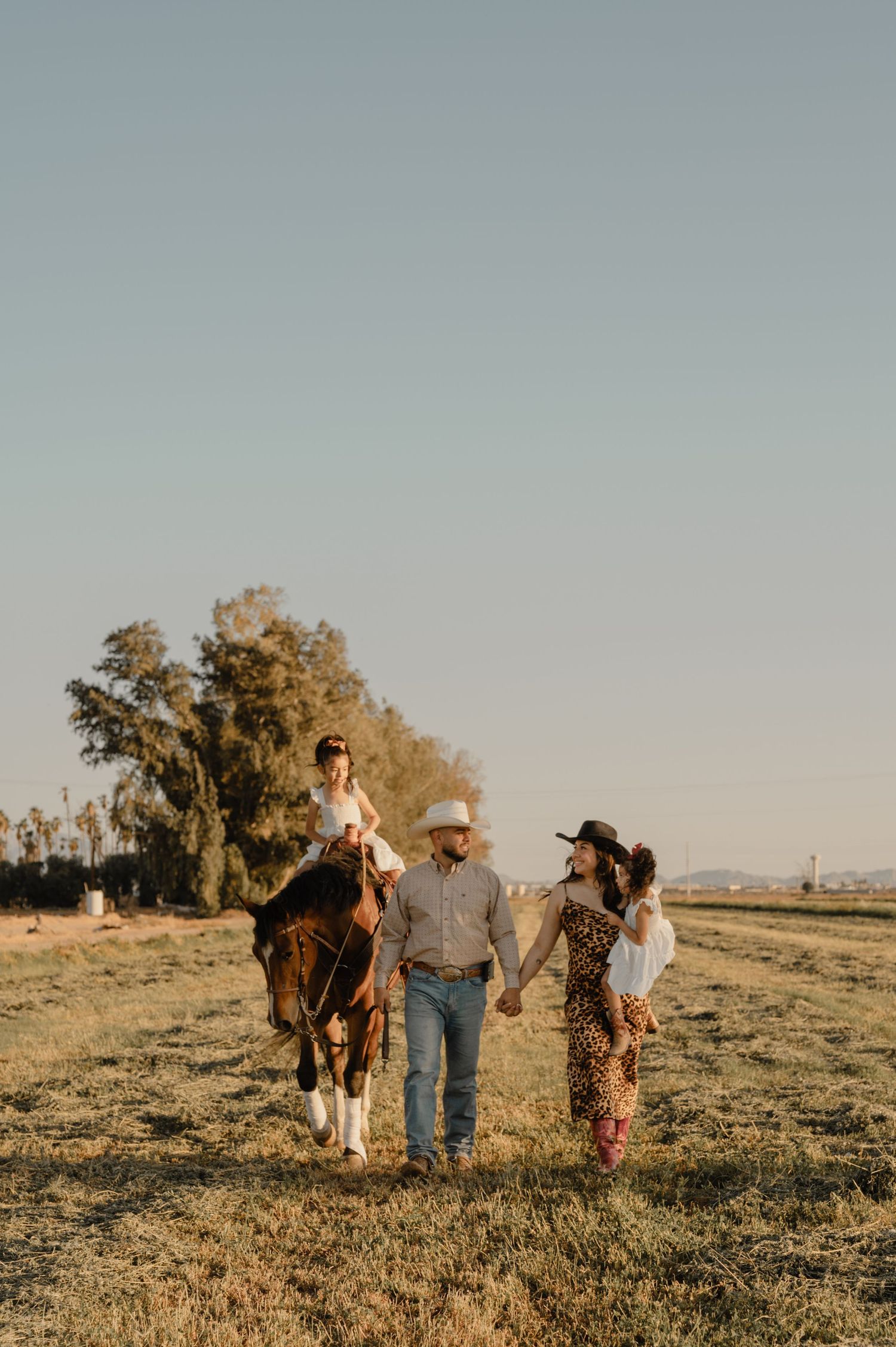 Candid outdoor family photo in Arizona field, walking together in golden light with soft, joyful energy.