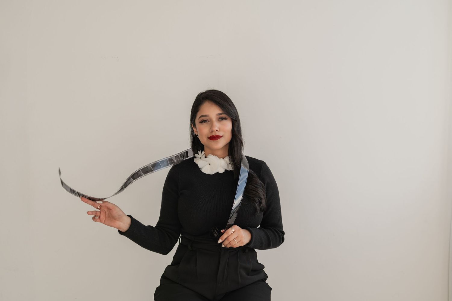 Woman playfully tossing camera strap over shoulder with a smile — joyful, relaxed branding image.