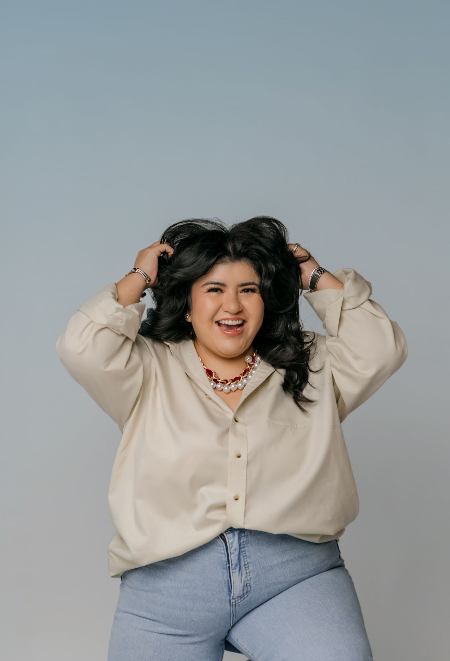 Sharom Rosas, founder of Shamari Visuals, laughs candidly with her hands in her hair during a personal branding session.