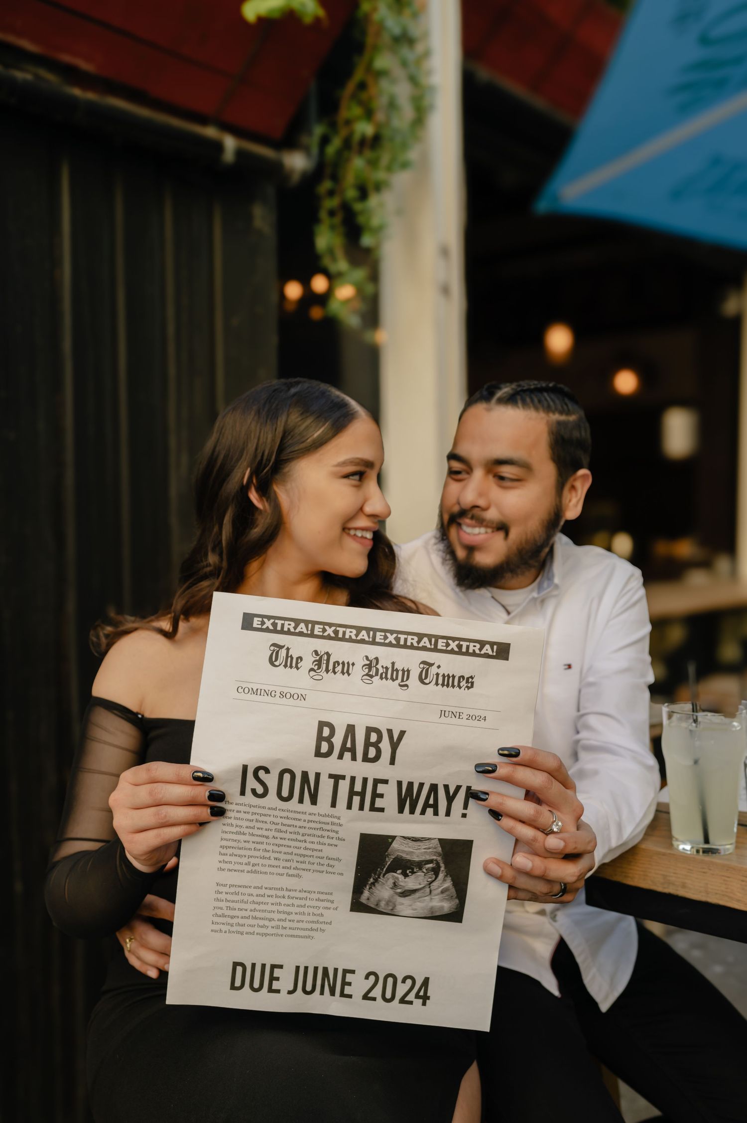 baby pregnancy announcement in downtown phoenix in front of cornish pasty holding a newspaper that reads baby on the way