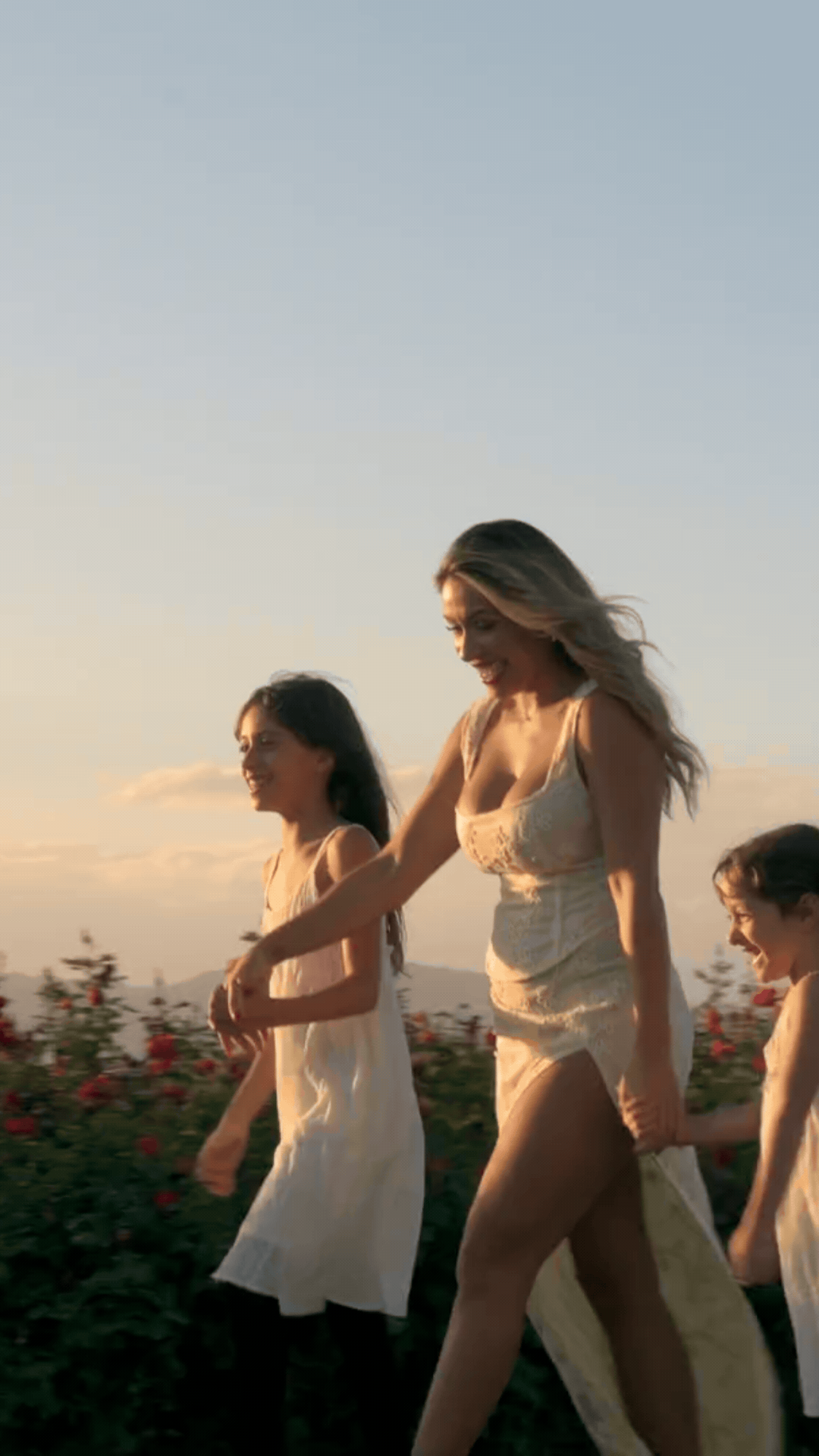 gif of woman and her two daughters walking in front of field