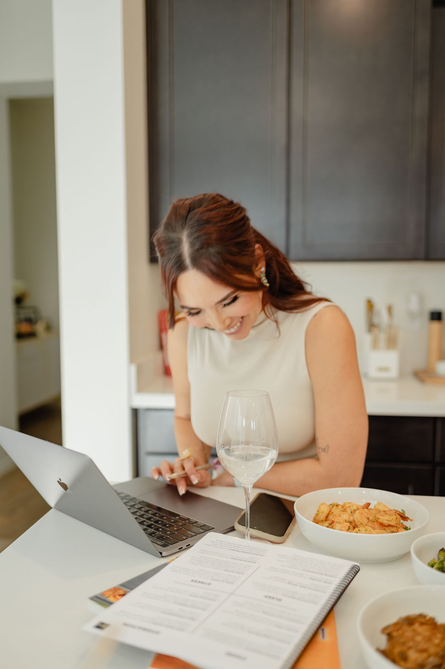 Diana in a modern kitchen, plating a healthy meal with focus and intention — clean, professional food prep setting.