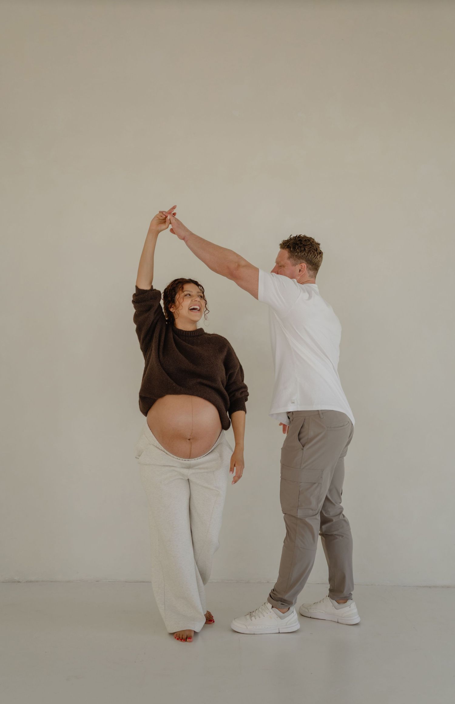 expecting couple dances together during a phoenix studio maternity session