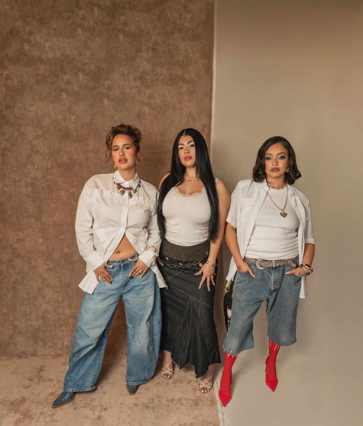Creative team portrait of three women posing confidently in styled outfits inside a Phoenix salon brand session.