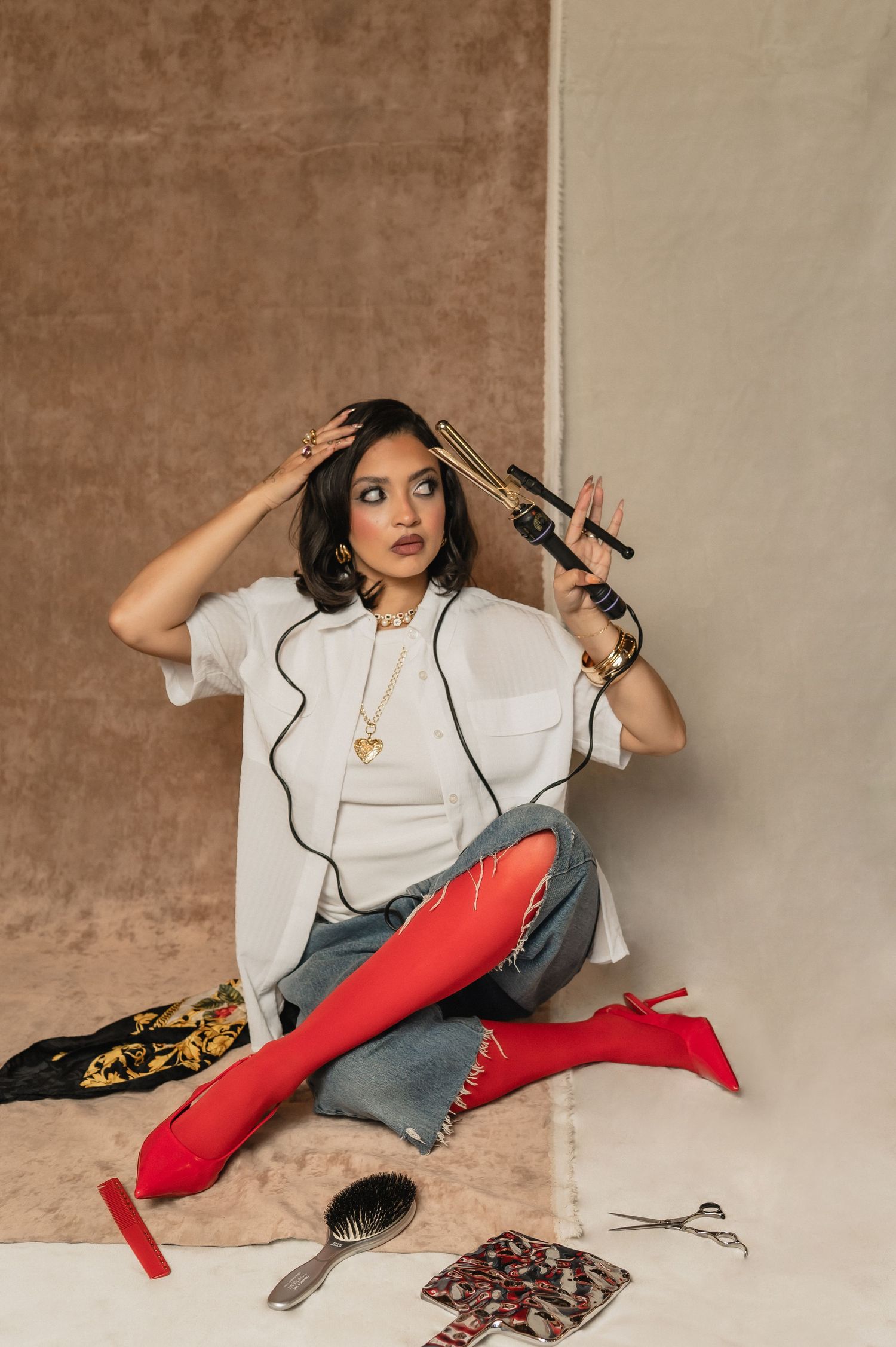 Creatively Kayla posing with beauty tools in red tights at The Hive salon in Phoenix, captured during a bold branding shoot.