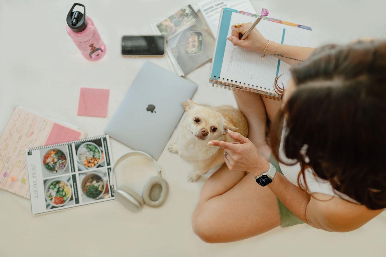 Flat lay of coaching tools: journals, cards, planner, and phone — creative and holistic coaching vibe.