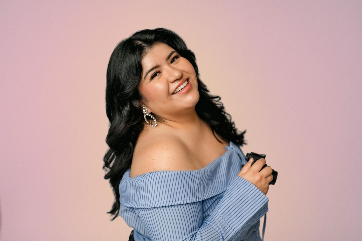 Sharom Rosas, founder of Shamari Visuals, smiling in a studio headshot.
