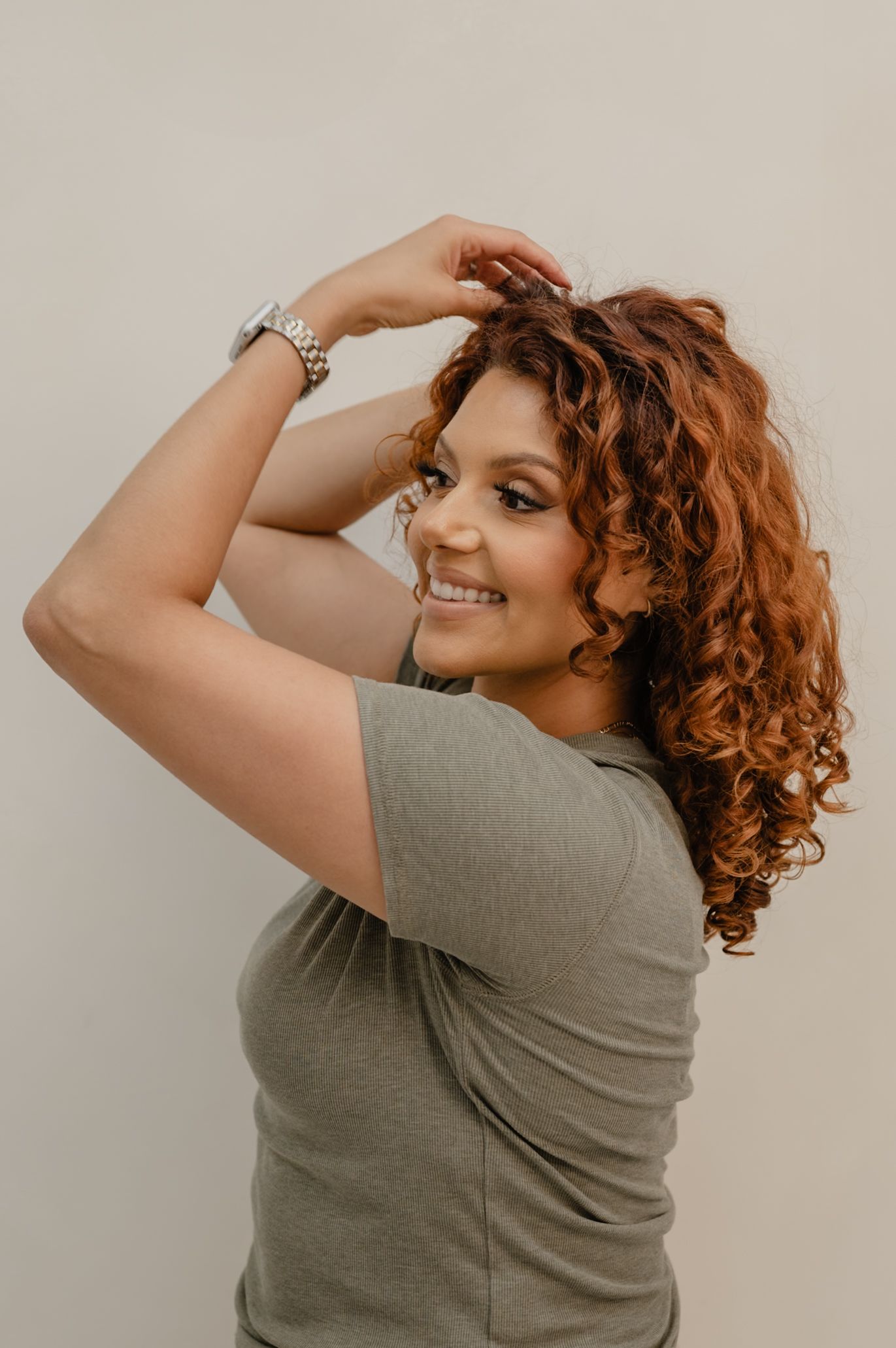 Curly hair specialist Serena posing playfully with hands in hair during a branding shoot in Peoria, Arizona.