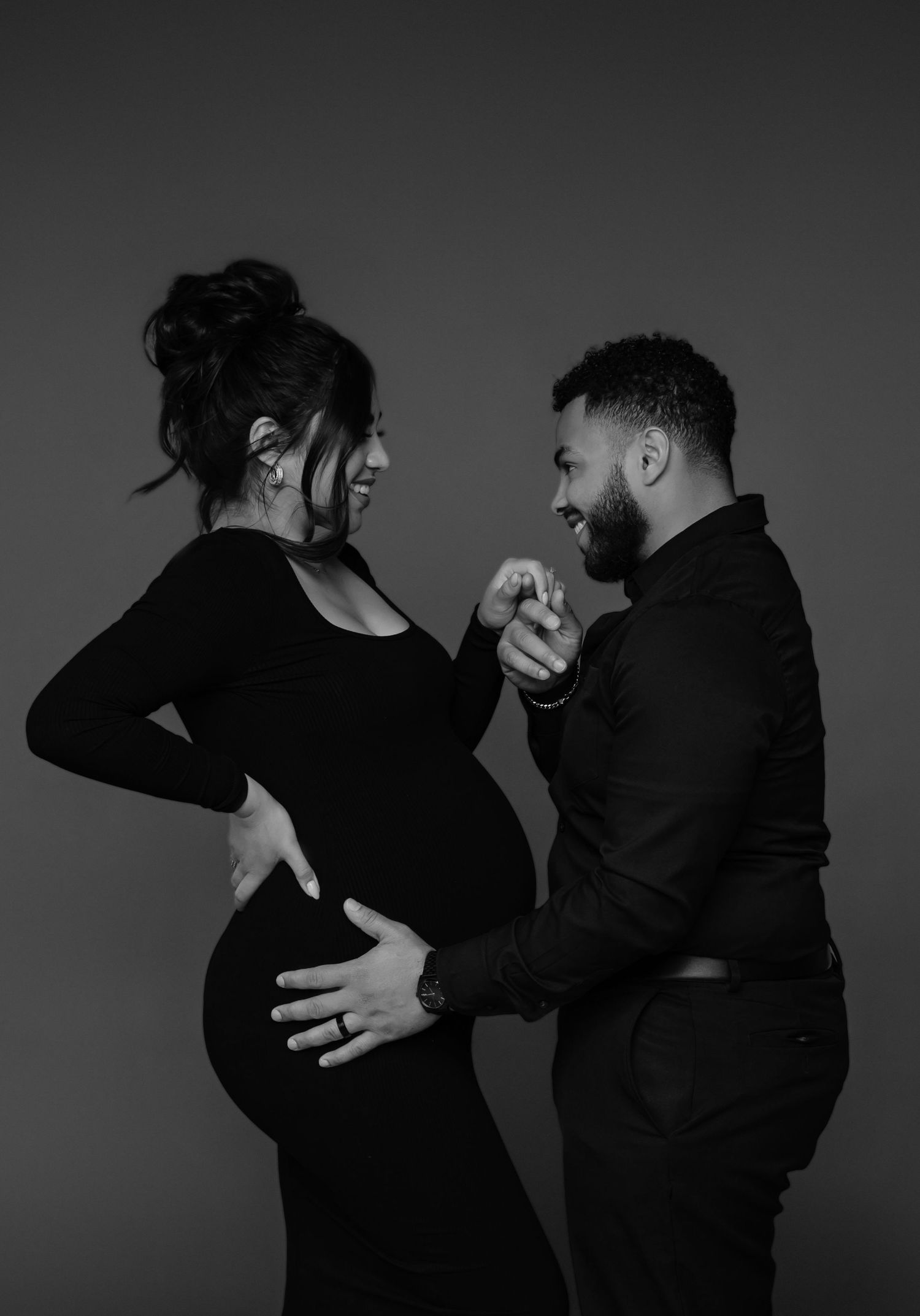 expecting couple shares a moment in matching black outfits during a phoenix editorial maternity session