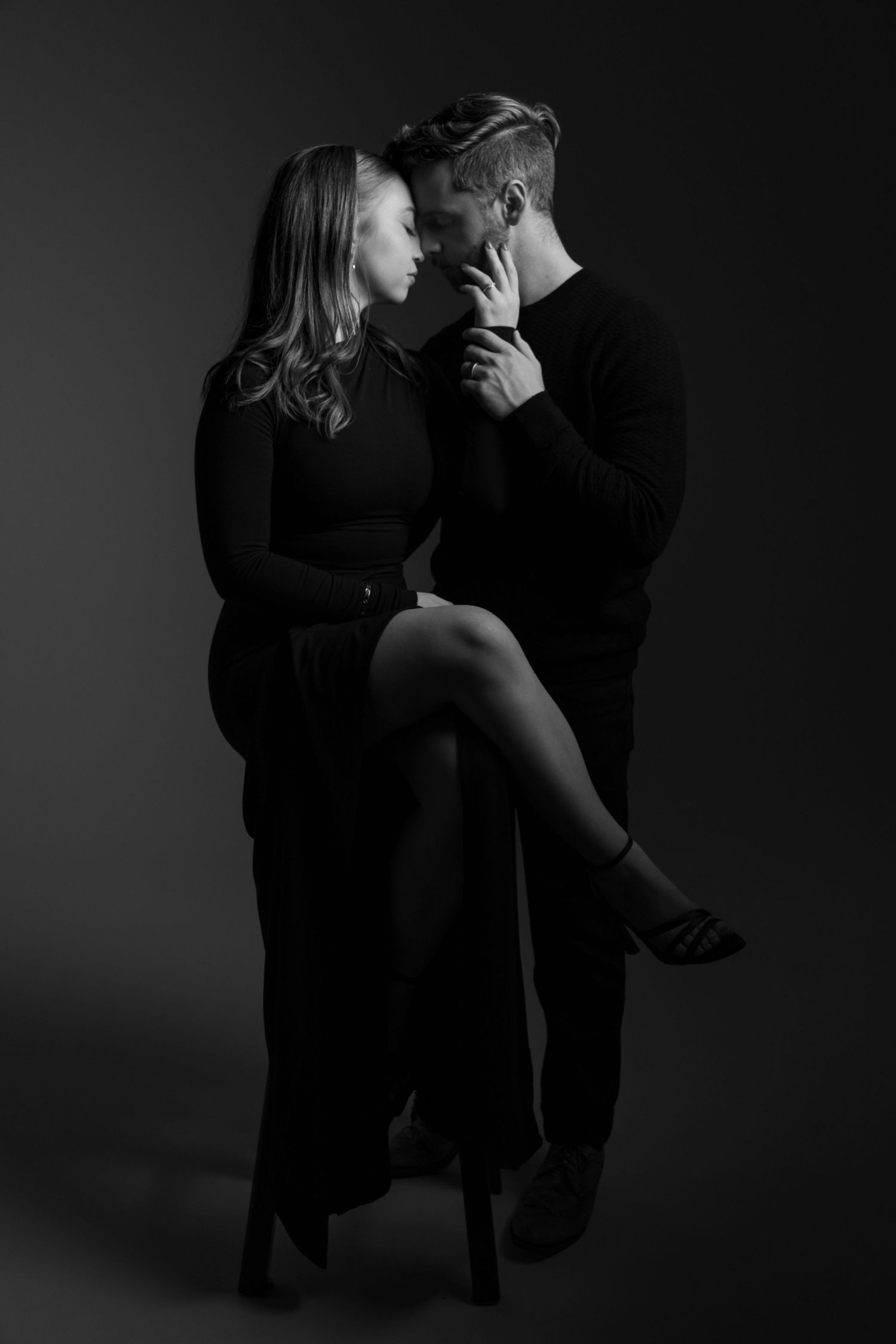 A dramatic black and white photo sequence shows a couple in intimate poses against a dark background.
