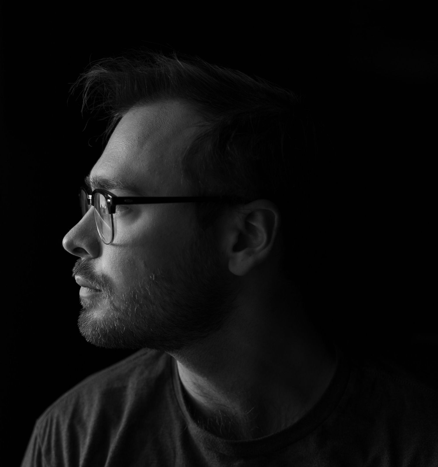 Low key portrait series showing dramatic side lighting in black and white.