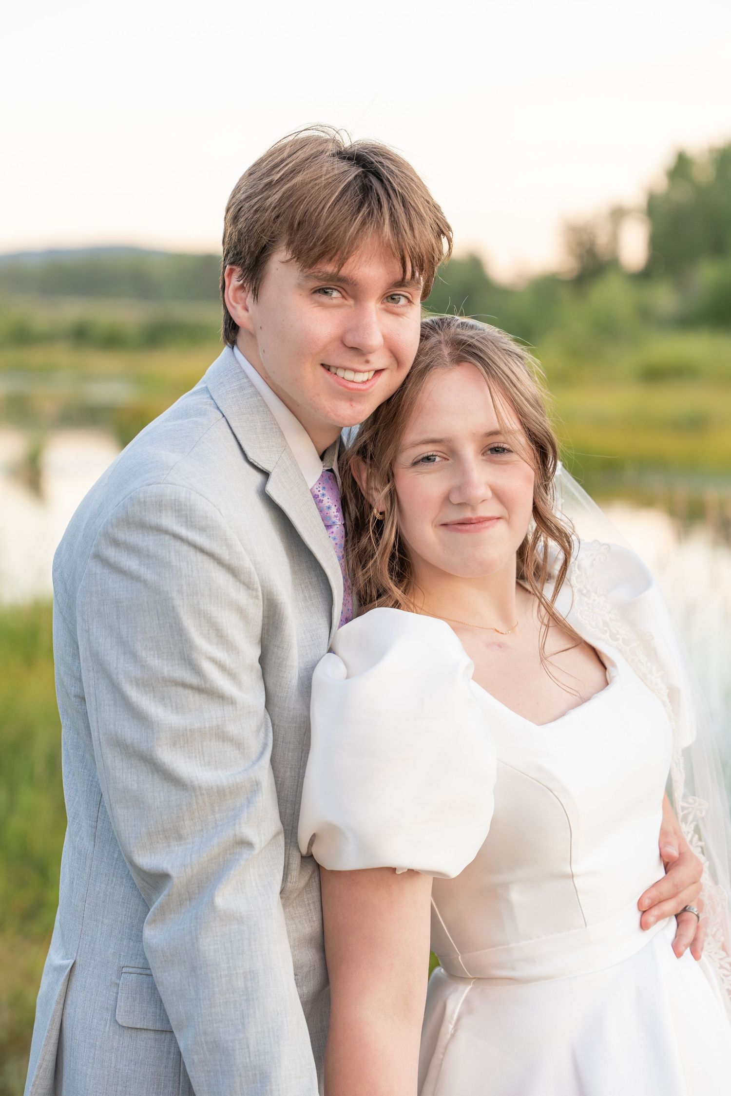 Sweet candid moments between newlyweds in outdoor summer setting.