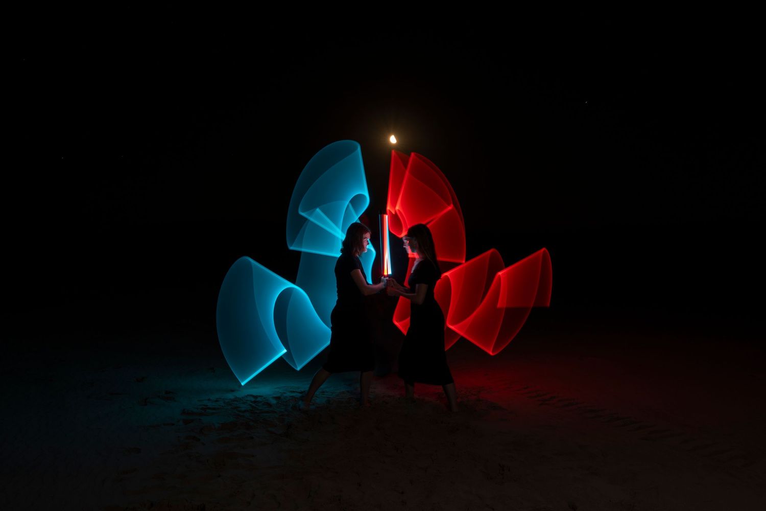 Light painting photography with blue and red illuminated shapes in darkness.