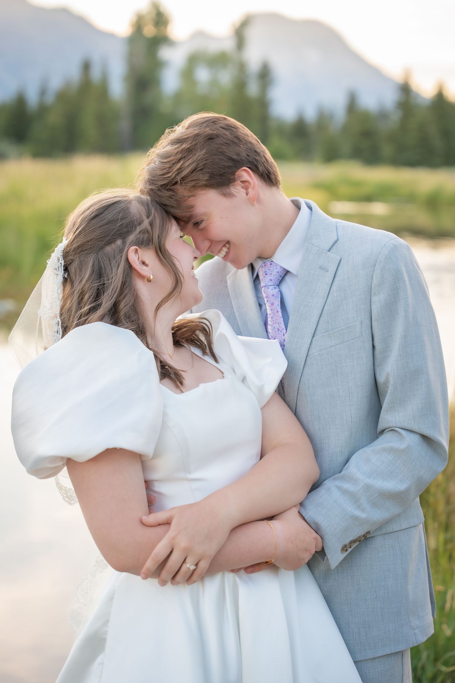 An intimate moment between newlyweds against a mountain backdrop during golden hour.