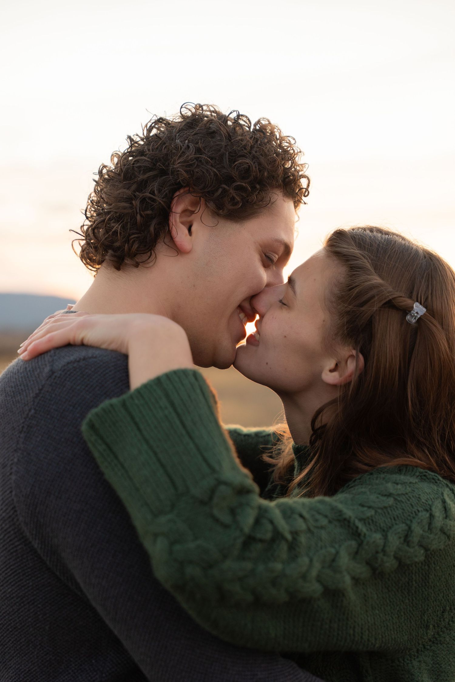 Intimate couple portrait with soft lighting against white background.