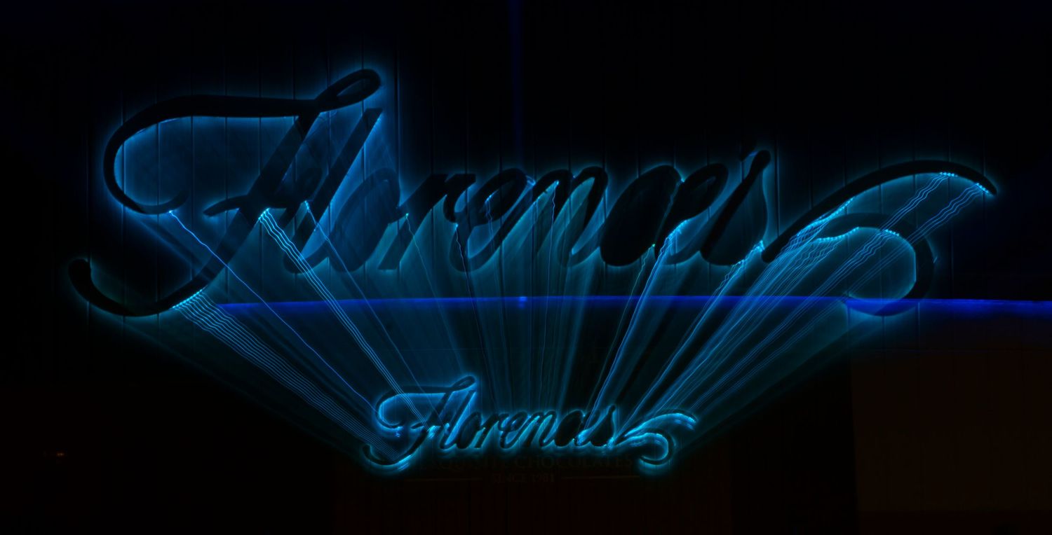 Blue neon light streaks create an abstract pattern on black background.