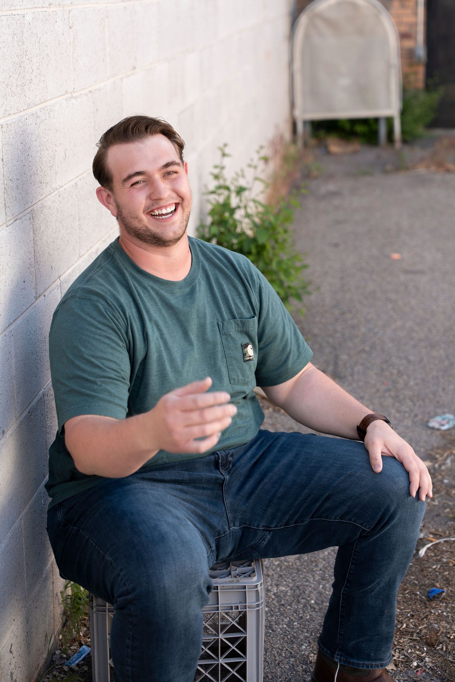 Casual portrait series showing relaxed poses while sitting on a concrete block.