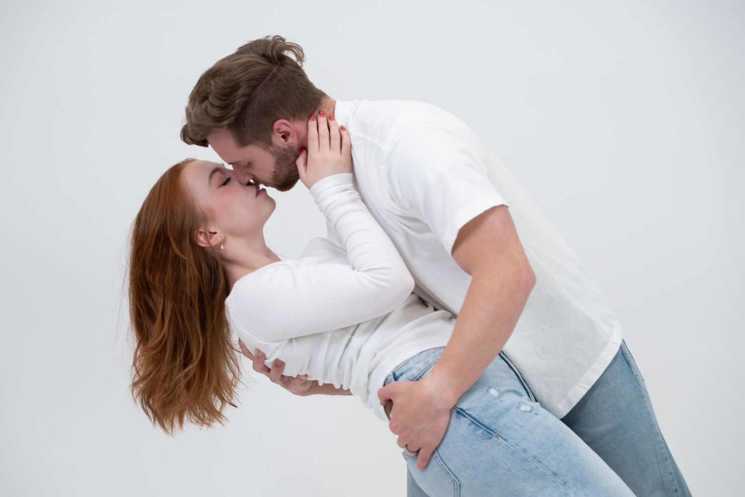 A series of dance movements showing a couple in white shirts and jeans performing contemporary dance poses together.
