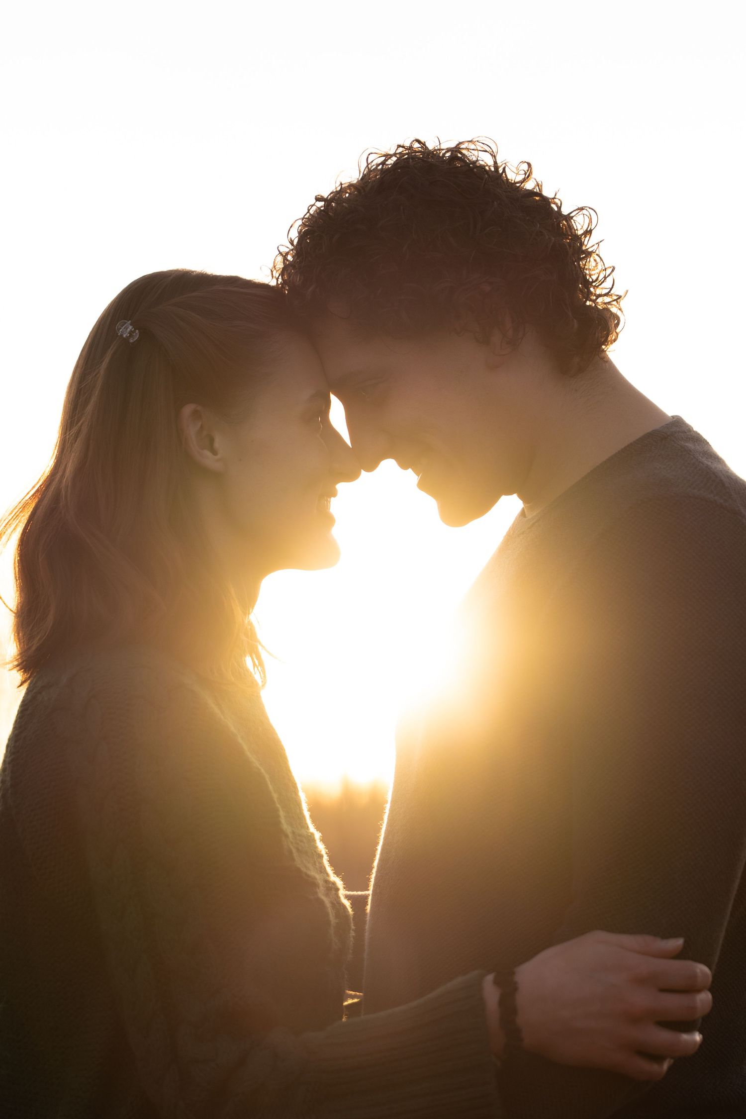 Romantic silhouettes of a couple against dramatic sunset lighting.