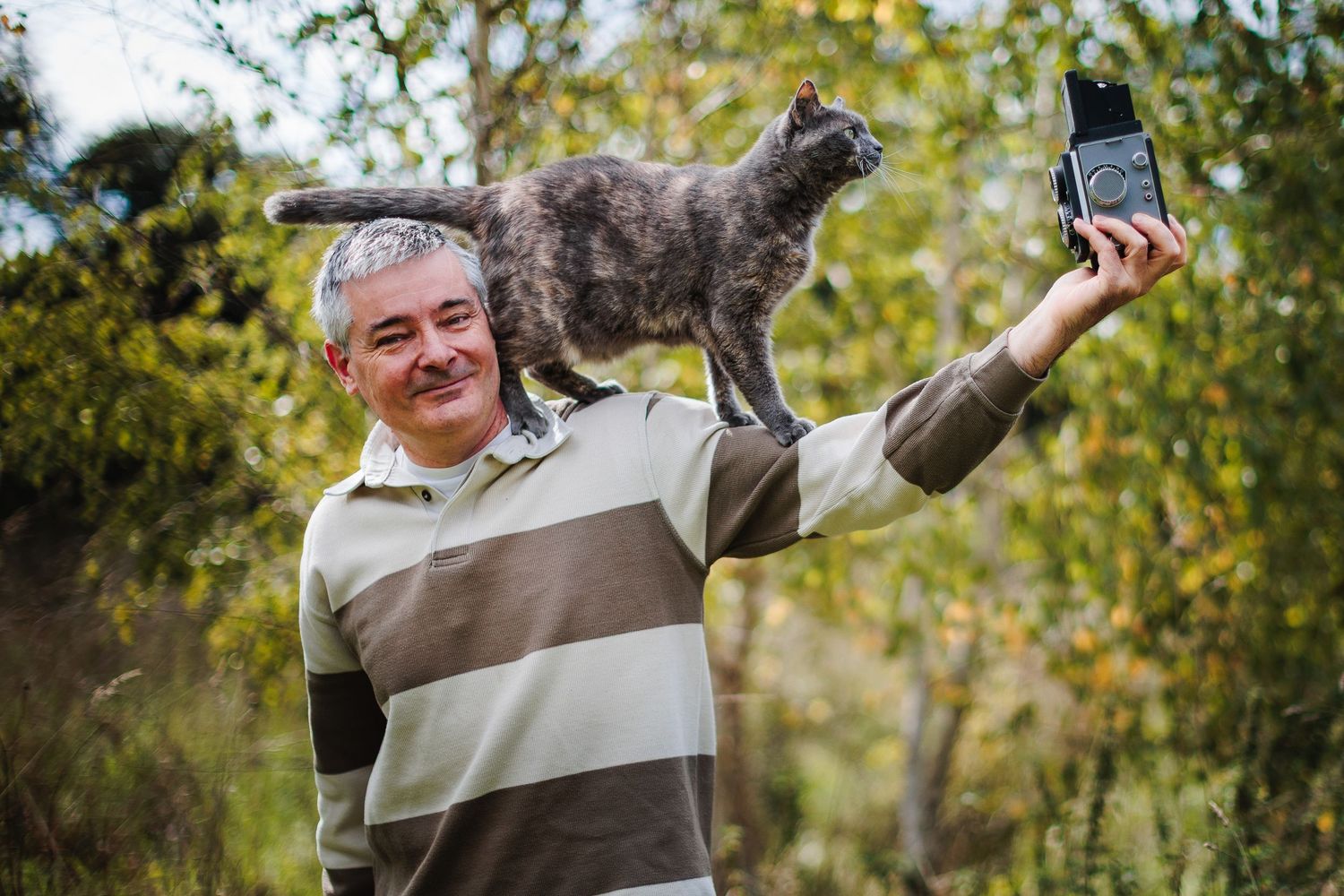 Portrait humoristique du photographe Eric Filliat avec son chat et un appareil moyen format, pour des séances photo en toute simplicité.