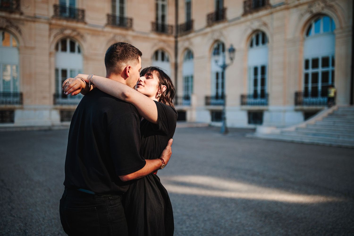 Baiser enlacé dans l'architecture marseillaise. Lumière graphique et pierres anciennes, séance photo de couple à Marseille.