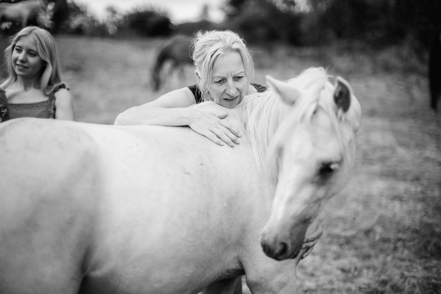 Mère et fille avec leur poney au champ. Un instant de tendresse et de complicité animale en noir et blanc, secteur Manzat - Servant