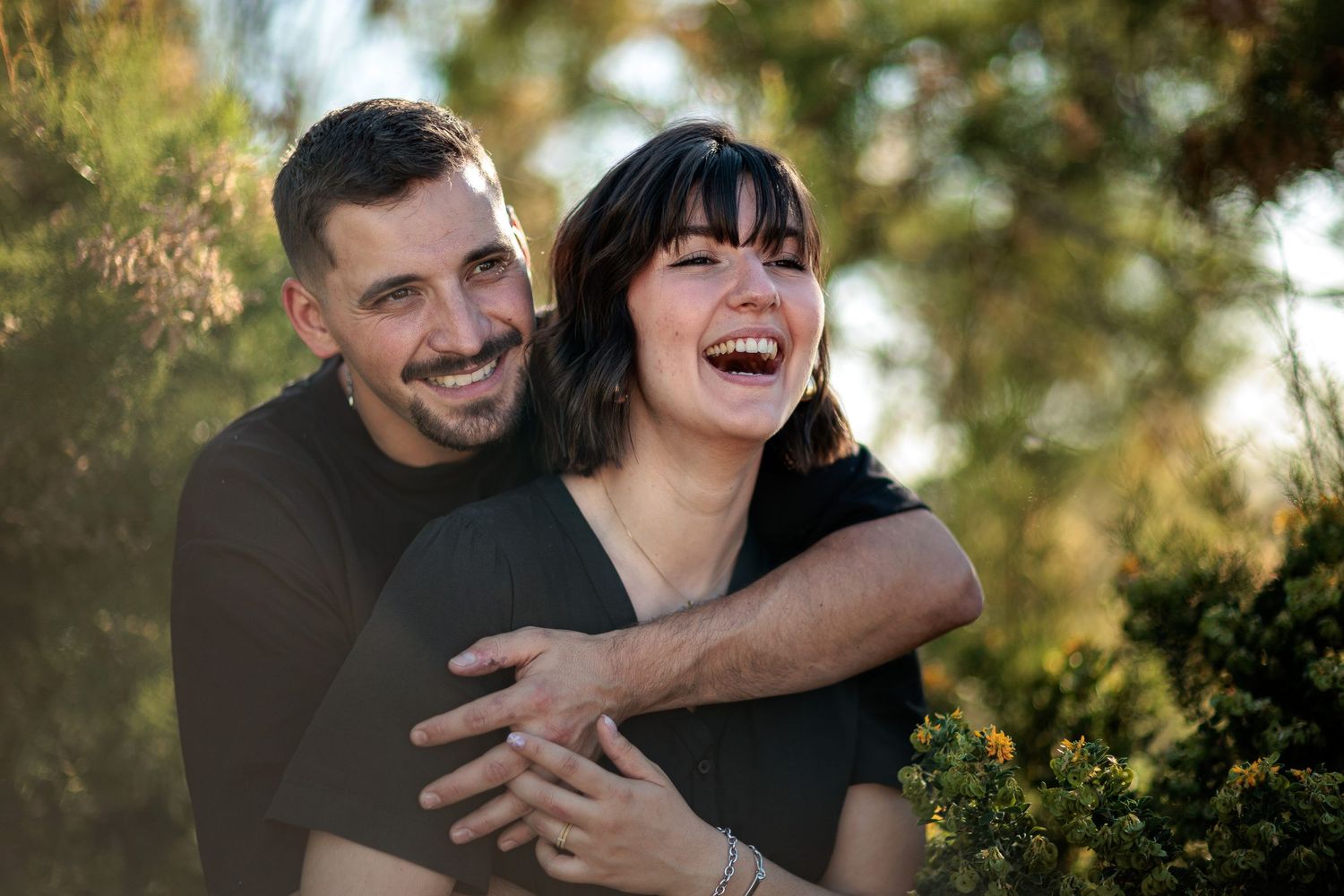 Éclat de rire et étreinte spontanée d'un couple face à la mer par Eric Filliat. Photographie de moments vrais. Provence, Cévennes & nature.