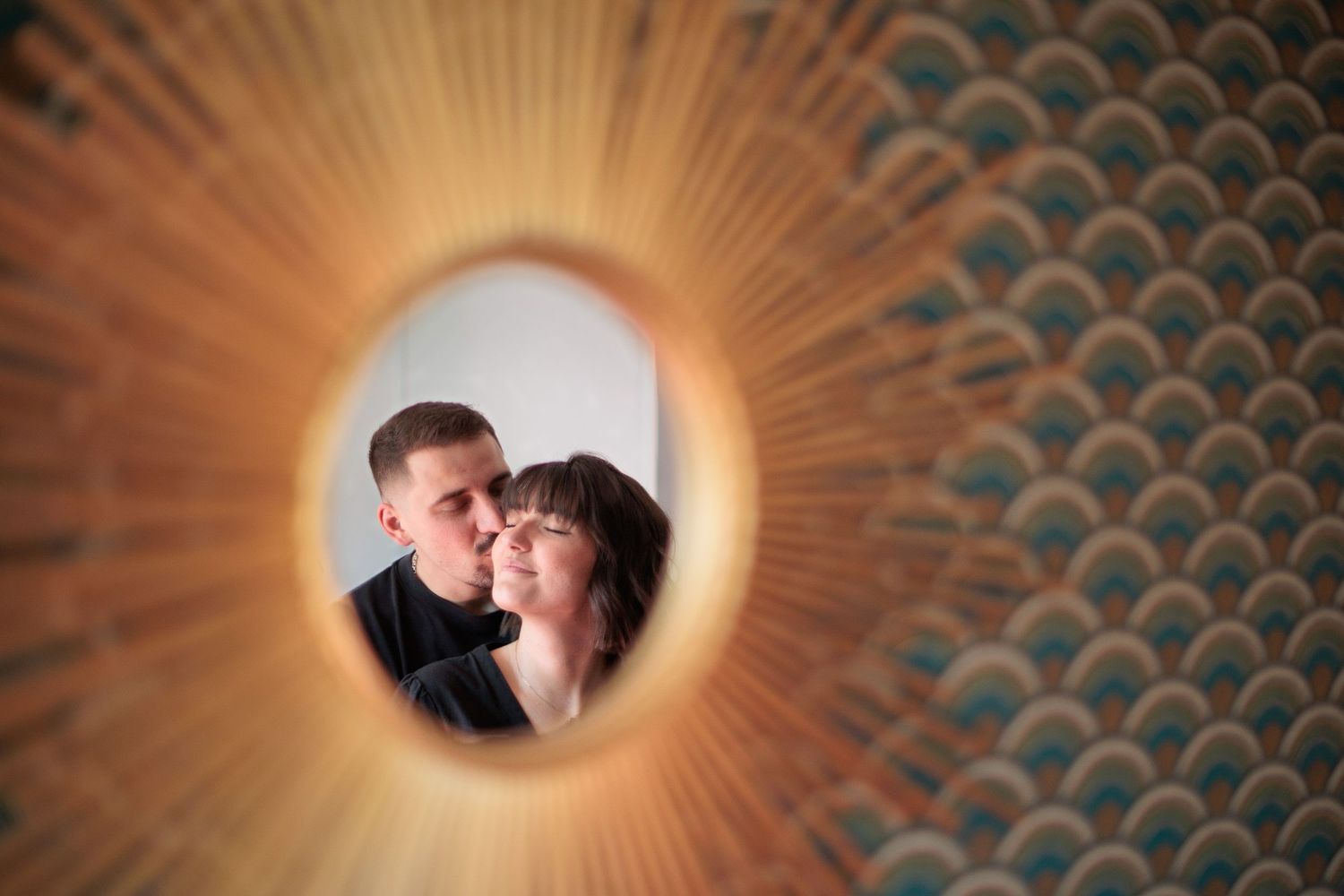 Un couple heureux et souriant, dans l'intimité du reflet du miroir de leur chambre. Eric Filliat, photographe couple & famille en Auvergne.