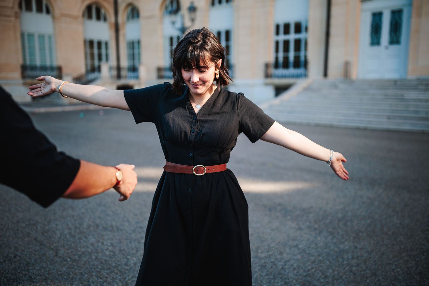Séance couple pour une jeune femme dansant dans les rues historiques de Marseille, main tendue de son compagnon par Eric Filliat.