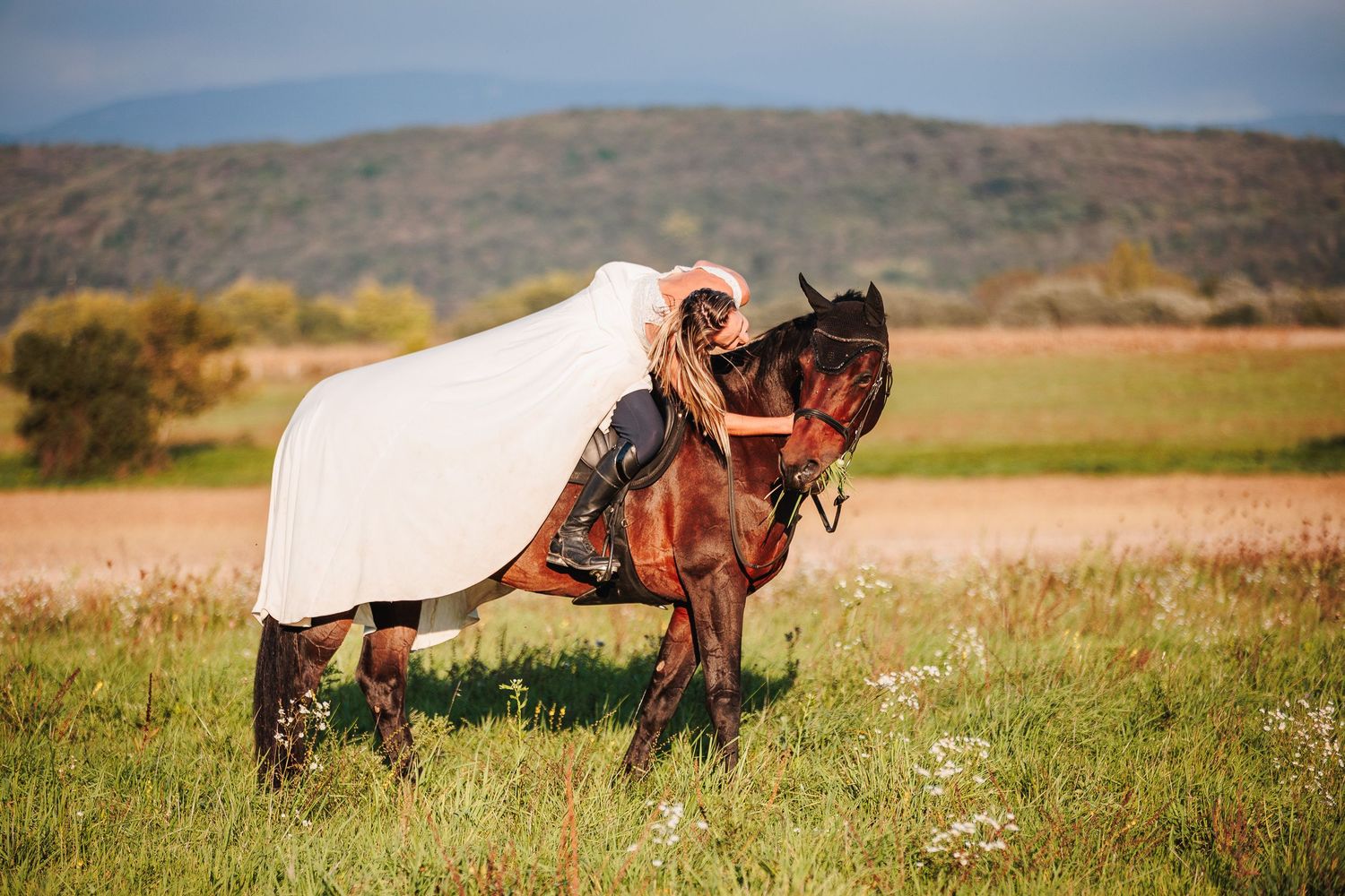 La mariée venue pour trash-the-dress, ne peut retenir un geste de complicité animale. Symbiose par Eric Filliat, photographe mariage à Vichy