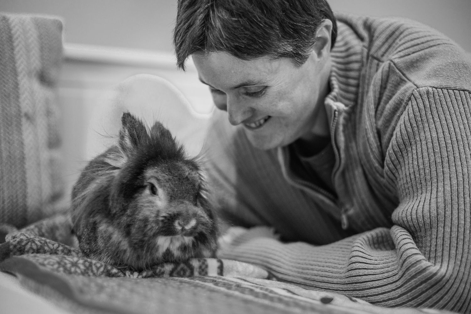 Lapin coquin et sa maîtresse souriante. Portrait animalier spontané en noir et blanc, secteur Brive-la-Gaillarde et Limousin.
