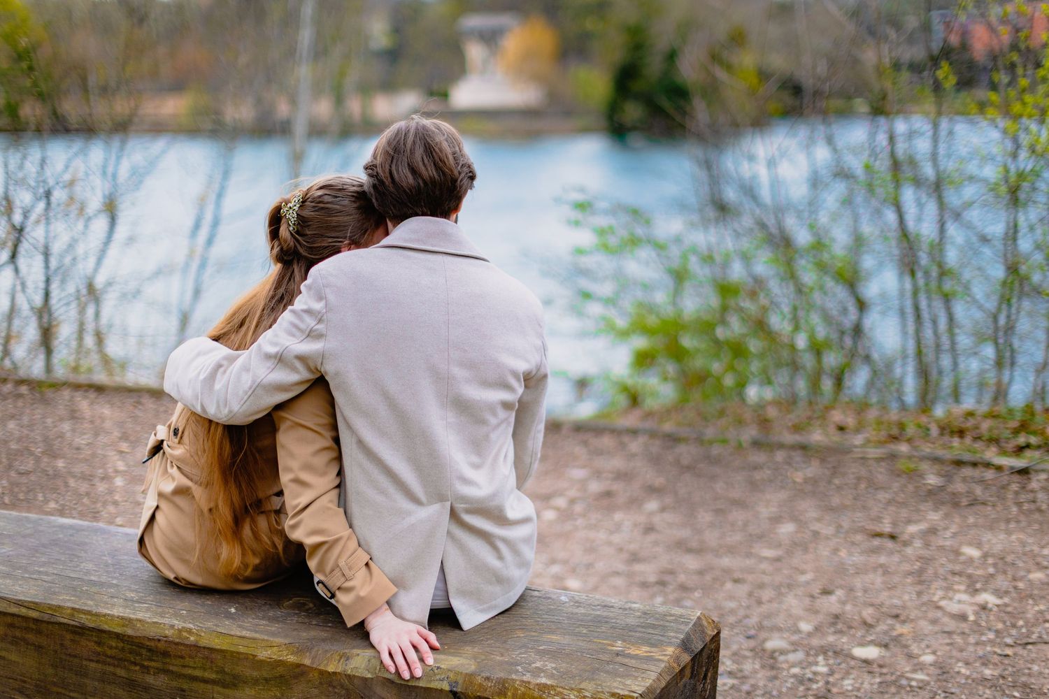 Couple enlacé de dos contemplant le lac du Parc de la Tête d'Or. Photographie de paysage et d'intimité par Eric Filliat.