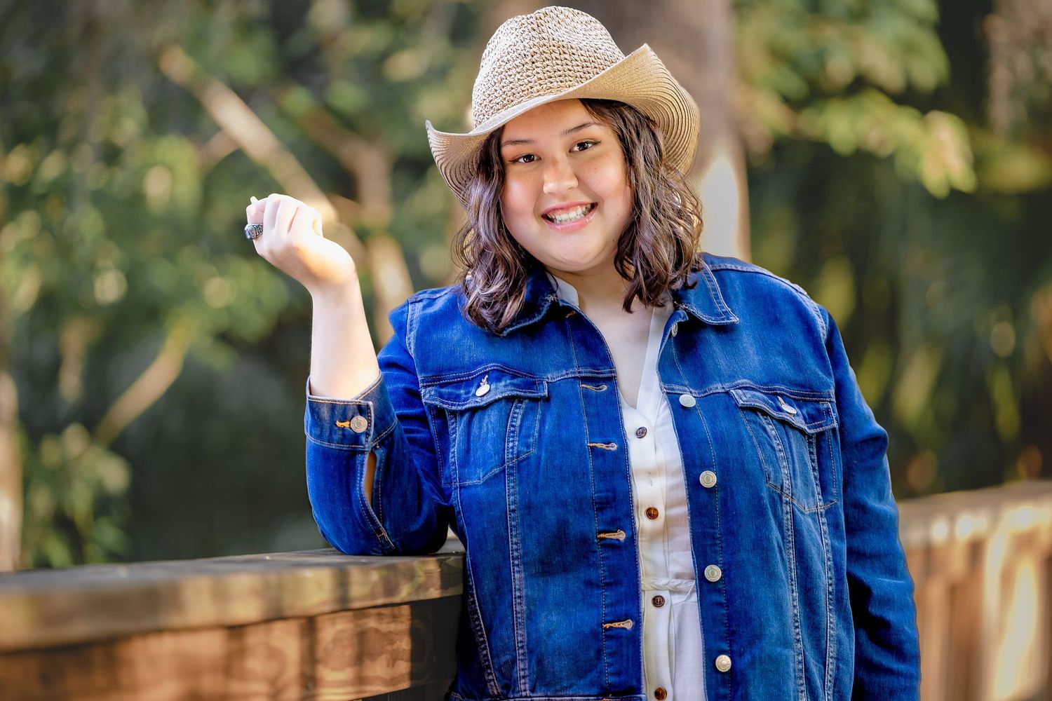 Fun outdoor portrait with denim and cowboy hat. Bright, confident, and full of personality