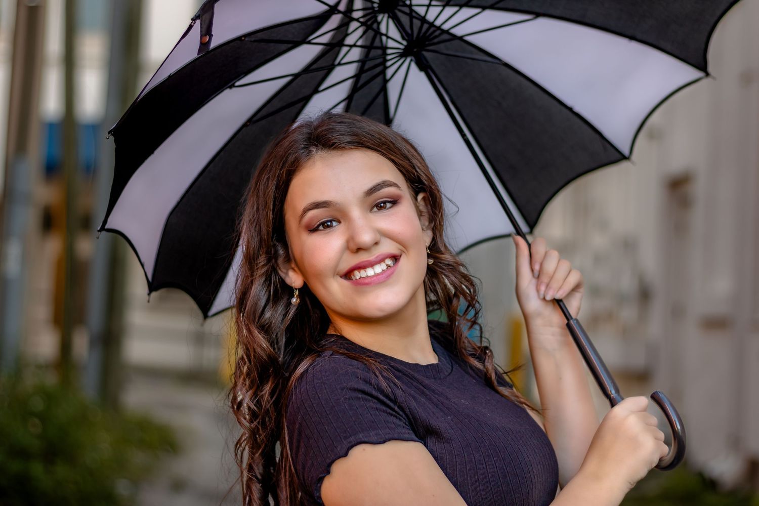 Playful teen photo with umbrella, bright smiles, confidence, and timeless charm.