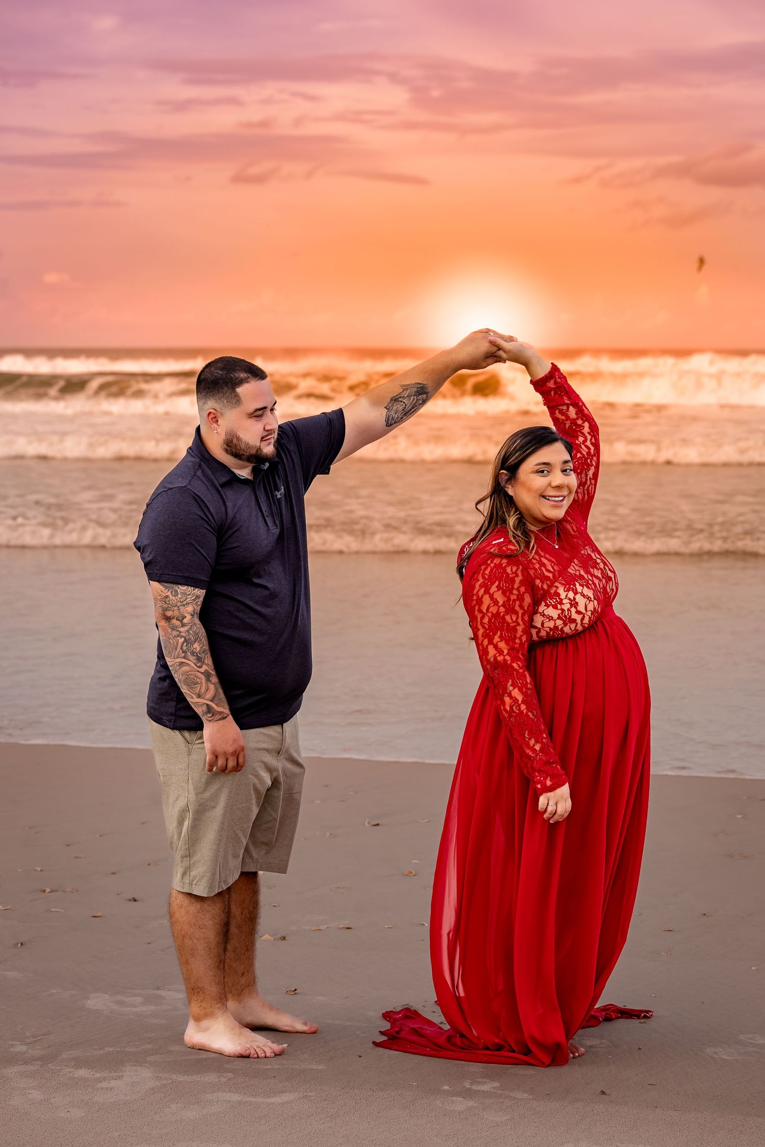 Sunset maternity session capturing love, motion, and golden-hour warmth on the beach.