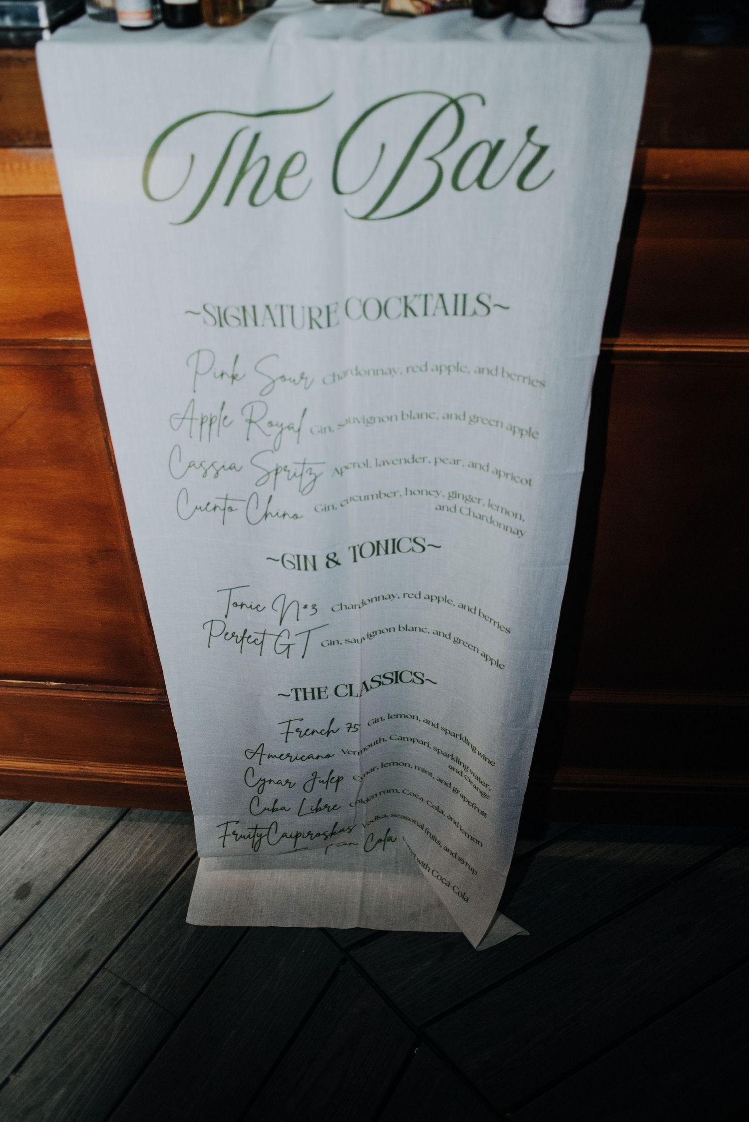 Elegant wedding bar menu banner with signature cocktails and classics written in calligraphy.
