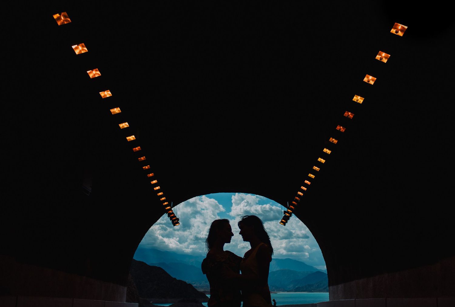 Silhouette of couple facing each other framed by a glowing tunnel arch.in wedding photographer in mendoza